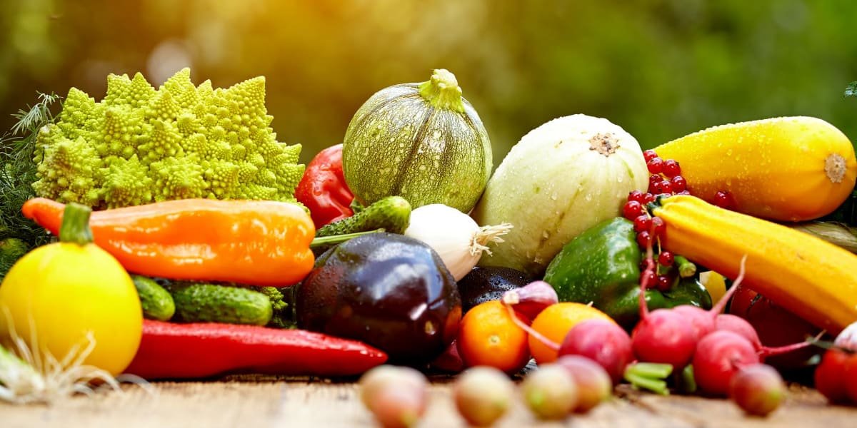 Frutta di stagione su tavolo di legno. Sfondo sfumato.